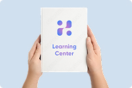 Hands holding a Learning Center booklet against a blue background | Hemmat Law Group