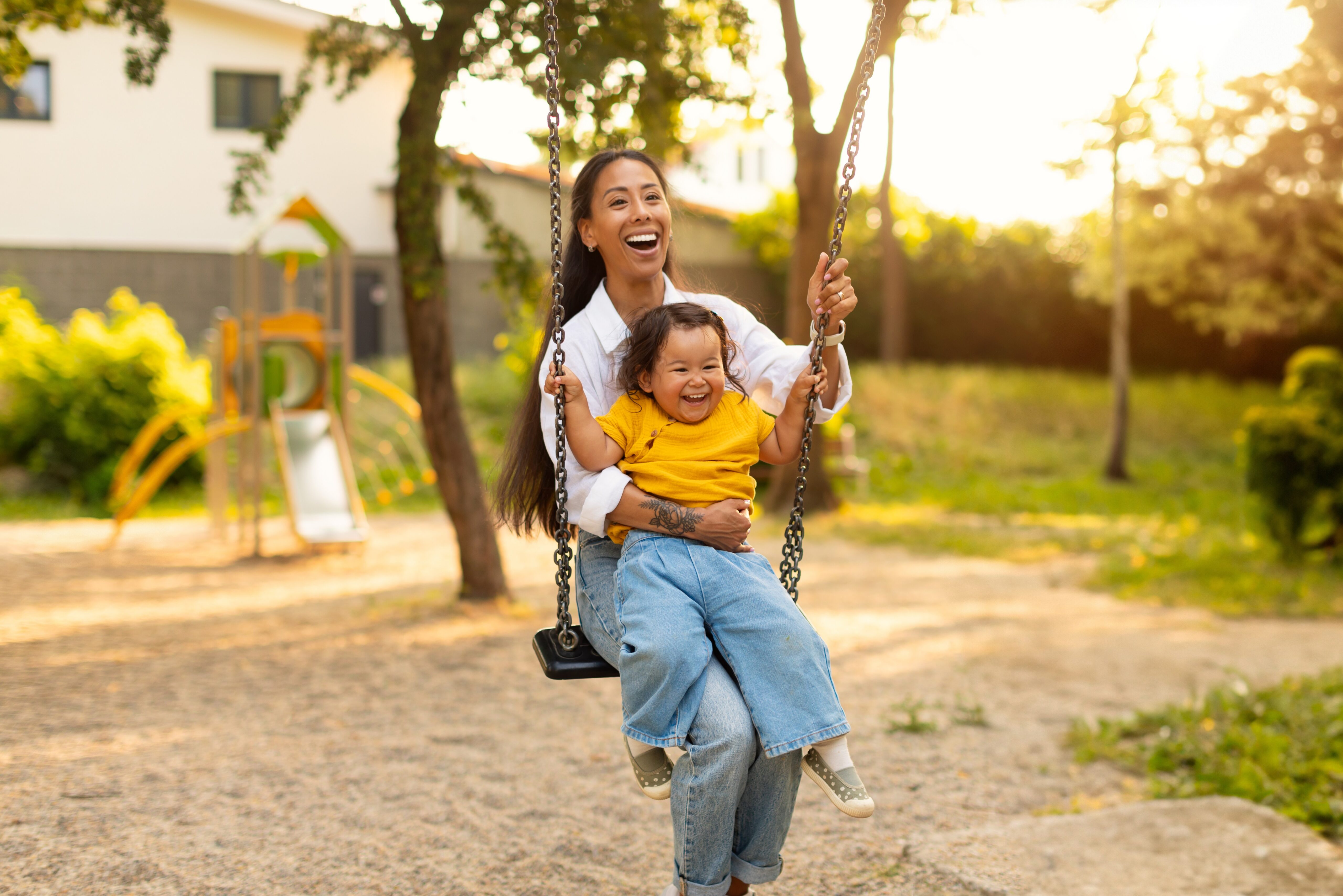 Mother and toddler laughing on a swing | Hemmat Law Group